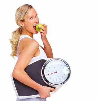 Young girl eating apple and carrying set of scales 